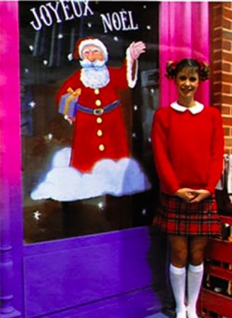 Dorothée pose devant une affiche du Père Noël avec des couettes